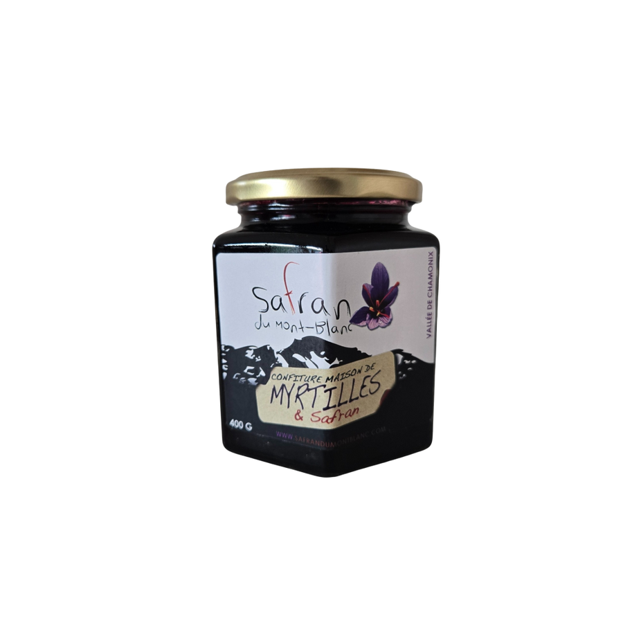 Jar of saffron and blackberry jam with a gold lid on a white background